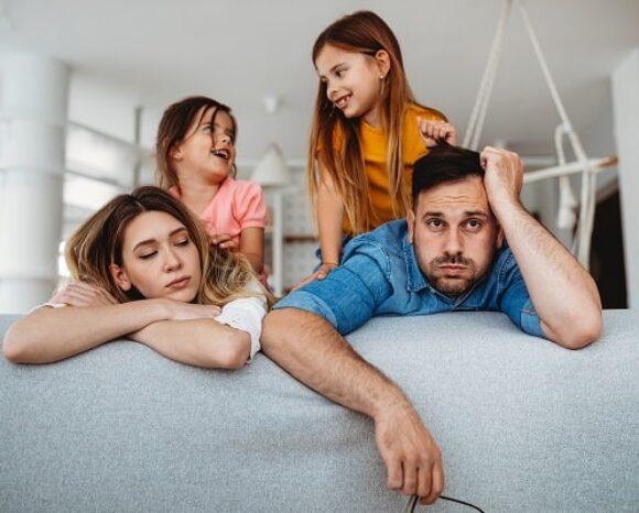 Gestresste Eltern mit aufgeweckten kleinen Kindern_weniger Stress durch Vier-Tage-Woche