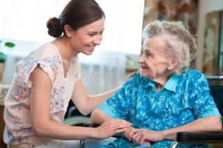 Ältere Dame schaut Pflegekraft lächelnd an