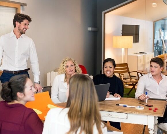 Kollegen arbeiten in Präsenzarbeit im Büro zusammen