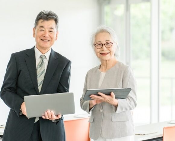 Betriebsrente, zwei ältere Mitarbeiter im Büro