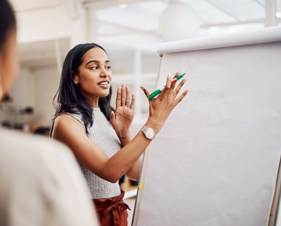 Eine Frau erklärt als Learnfluencerin etwas einem Mitarbeitenden.