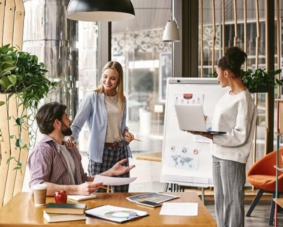 Lächelnde Kollegen arbeiten in einer New-Work-Bürolandschaft