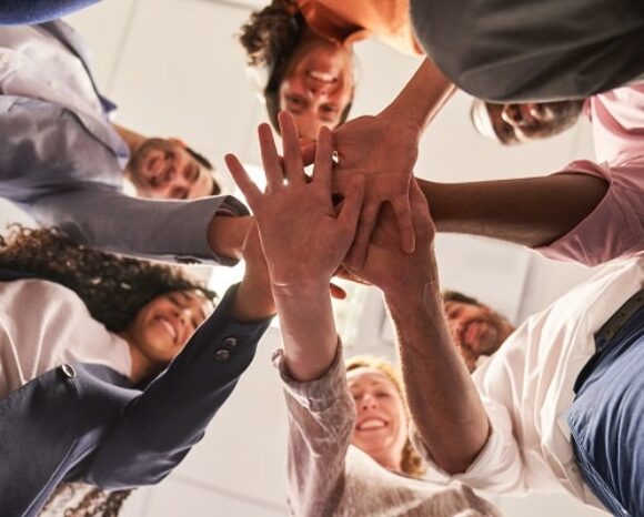 Viele Menschen legen Hände als Team aufeinander