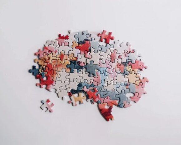 Ein Gehirn zusammengesetzt aus verschiedenen bunten Puzzleteilen
