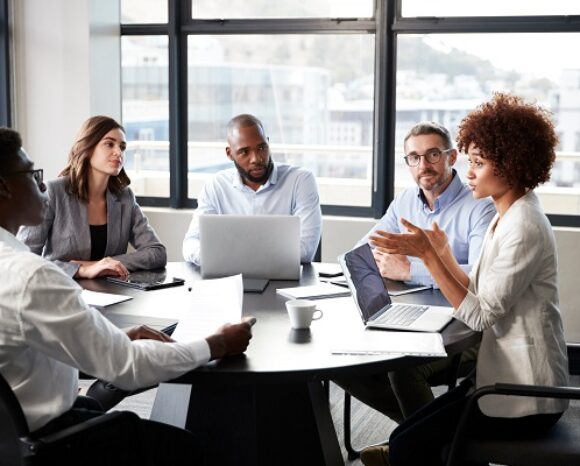 Kollegen sitzen am Tisch und reden über das Gehalt