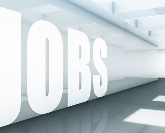 Auf einer transparenten Wand steht in großen Buchstaben JOBS