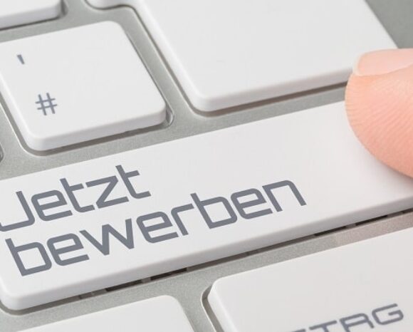 Mensch klickt auf "Jetzt bewerben" auf Tastatur