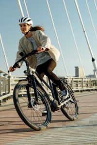 Frau fährt mit geleastem Fahrrad über Brücke
