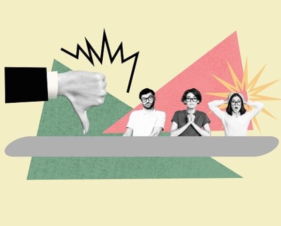 Drei Menschen sitzen am Tisch und schauen entsetzt, ein großer Daumen zeigt nach unten, weil die Unternehmen Personalprobleme haben.