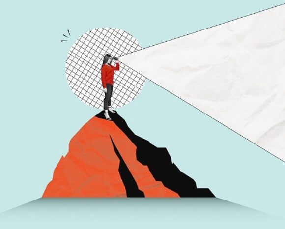 Frau steht auf einem Hügel und schaut in die Ferne bzw Zukunft