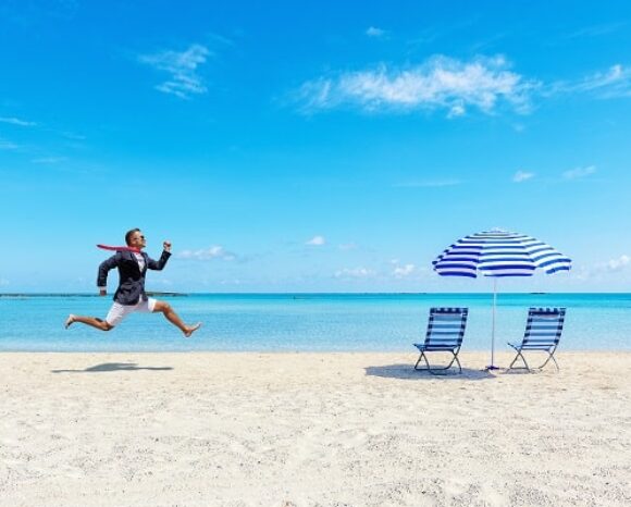 Mann rennt im Business-Anzeig über den Strand, vom Büro in den Urlaub