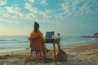 Frau arbeitet am Strand an einem Schreibtisch
