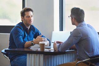 Mitarbeiter unterhält sich mit seinem Chef im Mitarbeitergespräch