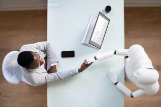 Roboter bzw KI schüttelt Bewerber die Hand.
