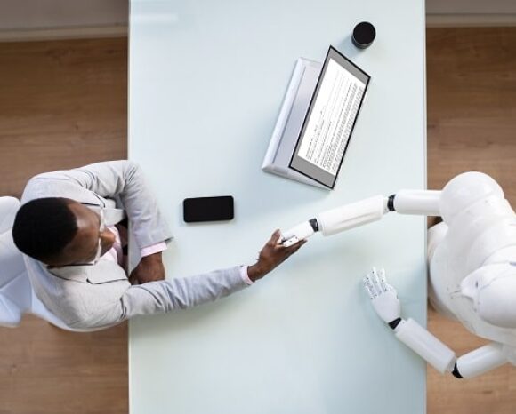 Roboter bzw KI schüttelt Bewerber die Hand.