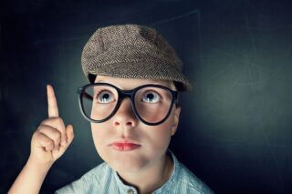 Quereinsteiger, Kind mit Brille und Mütze zeigt mit Finger auf