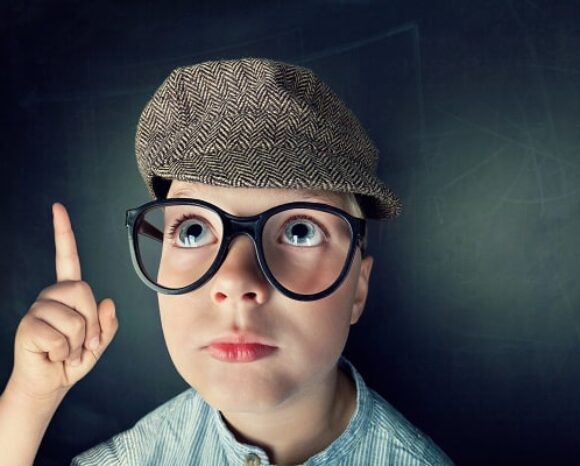 Quereinsteiger, Kind mit Brille und Mütze zeigt mit Finger auf