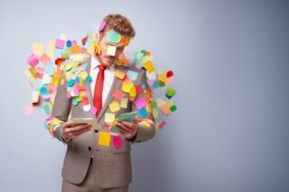 Mann leidet unter Mehrarbeit und hat überall Post-its auf dem Anzug