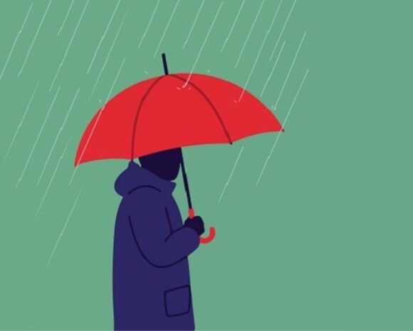 Mann mit rotem Regenschirm steht im Regen