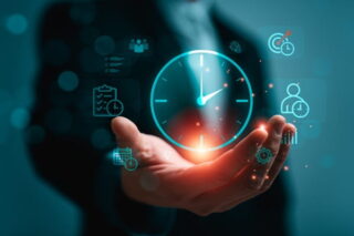 Mann hält digitale Uhr in den Händen, Zeitwirtschafts-Symbole befinden sich rundherum