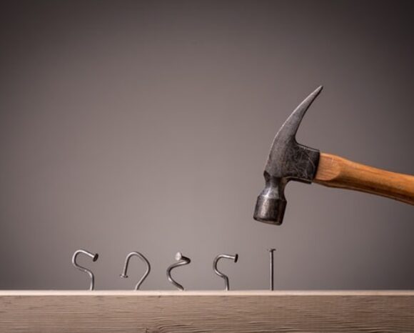 Hammer schlägt Nägel schief ein