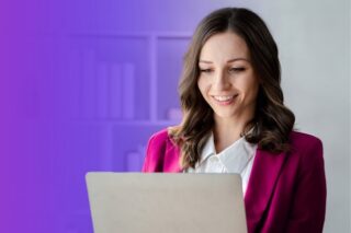 Frau arbeitet lächelnd am Laptop