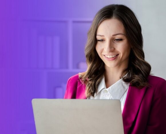 Frau arbeitet lächelnd am Laptop