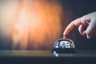 Hand betätigt eine Klingel