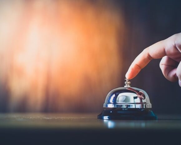 Hand betätigt eine Klingel