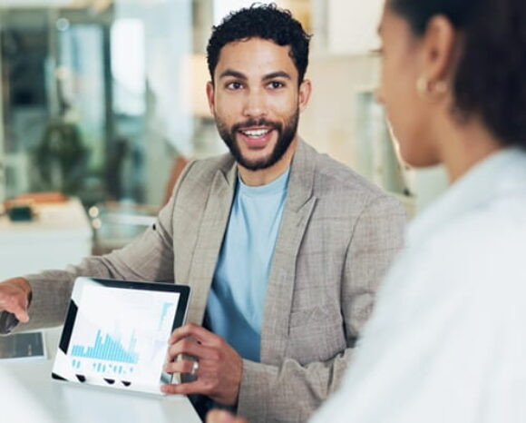 Mann und Frau reden über Zahlen auf einem Tablet