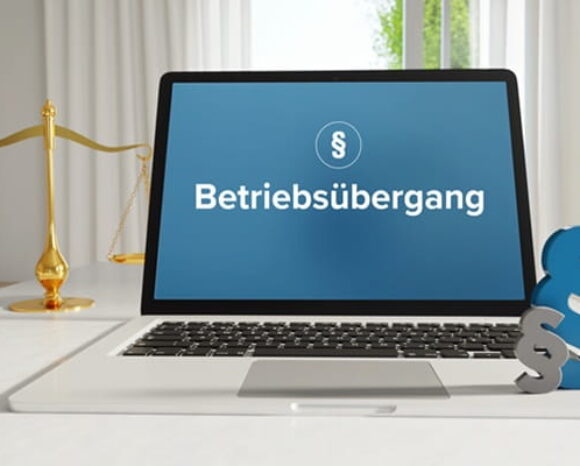 Auf einem Laptop wird "Betriebsübergang" eingeblendet