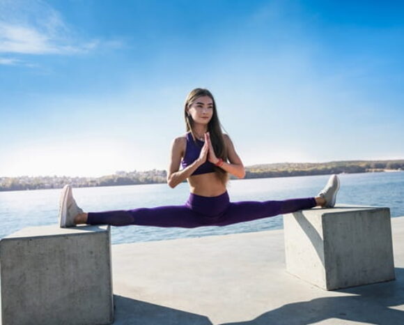 Frau macht einen Spagat über zwei Betonklötze