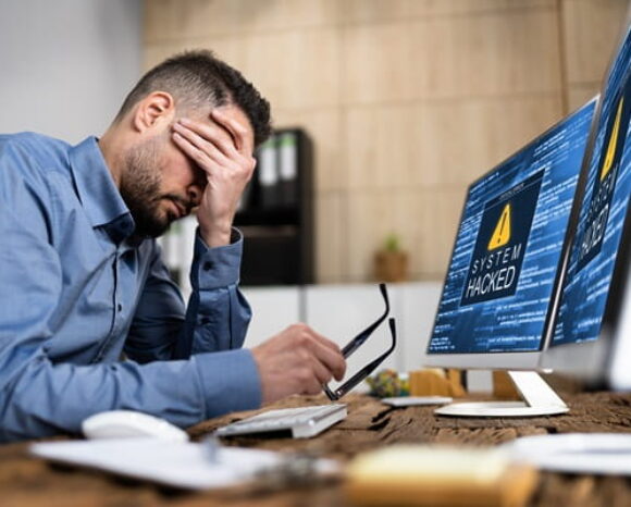 Mann hat einen Sicherheitsvorfall durch einen Cyberangriff begangen und legt verzweifelt das Gesicht in seine Hand