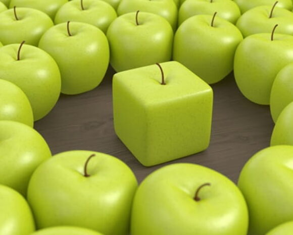 Grüne runde Äpfel umringen einen kantigen grünen Apfel