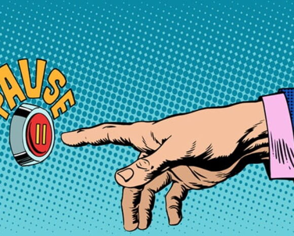 Hand drückt auf Knopf mit Pause