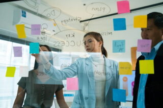 Kollegen reden mit einem Coach über Änderungen der Organisations-Struktur