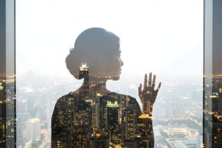 Frau schaut aus einem Wolkenkratzer durch das Fenster nach draußen