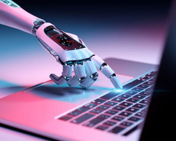 Hand, die KI darstellen soll, tippt auf eine Taste am Laptop