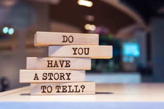 Auf Holzklötzchen steht: Do you have a story to tell?