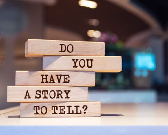 Auf Holzklötzchen steht: Do you have a story to tell?