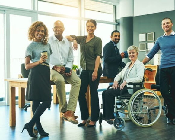 Diverses Team, unterschiedliche Menschen stehend und im Rollstuhl