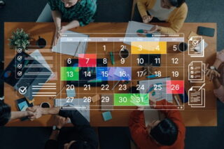 Team-Mitglieder diskutieren über Wochenarbeitszeit, Kalender im Vordergrund