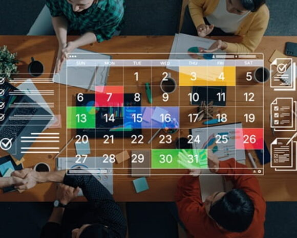 Team-Mitglieder diskutieren über Wochenarbeitszeit, Kalender im Vordergrund