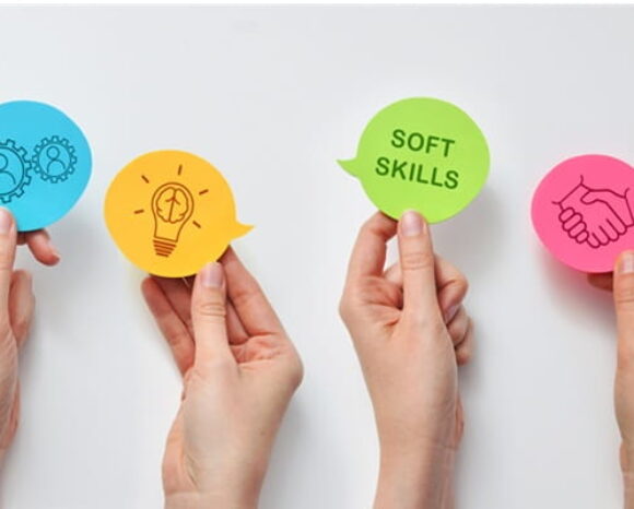 Hände halten verschiedene Symbole zu Soft Skills hoch