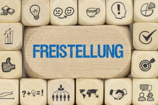 auf einem großen Würfel steht in blauer Schrift "Freistellung", ringsherum sind kleine Würfel mit Icons