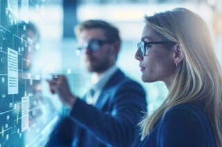 Eine Top-Managerin und ein Top-Manager schauen auf ein visuelles Board