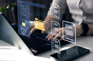 Frau gibt etwas am Laptop in die digitale Entgeltakte ein