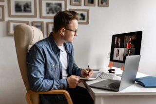 Mann arbeitet im Homeoffice und hat eine Videokonferenz