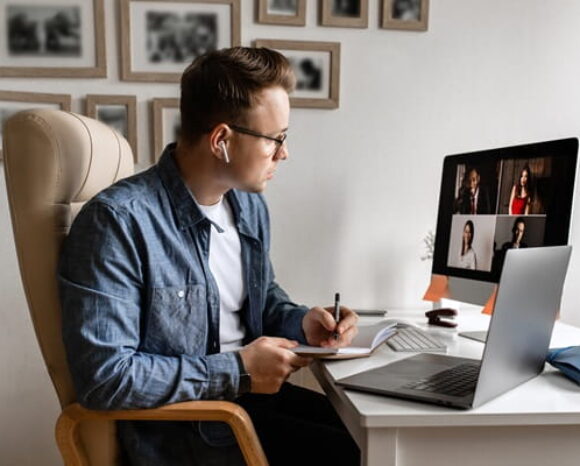 Mann arbeitet im Homeoffice und hat eine Videokonferenz