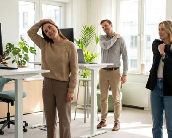 Kollegen machen Dehnübungen im Büro